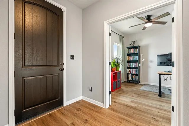 a view of a hallway with wooden floor and closet