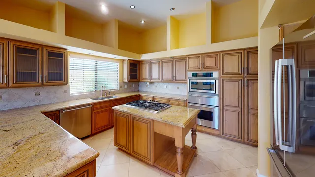 a kitchen with stainless steel appliances granite countertop a sink stove and refrigerator