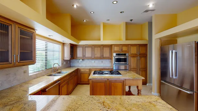 a kitchen with stainless steel appliances granite countertop a stove and cabinets