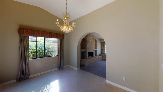 an empty room with windows and ceiling fan