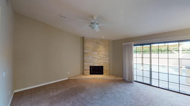 a view of an empty room with a fireplace and a window