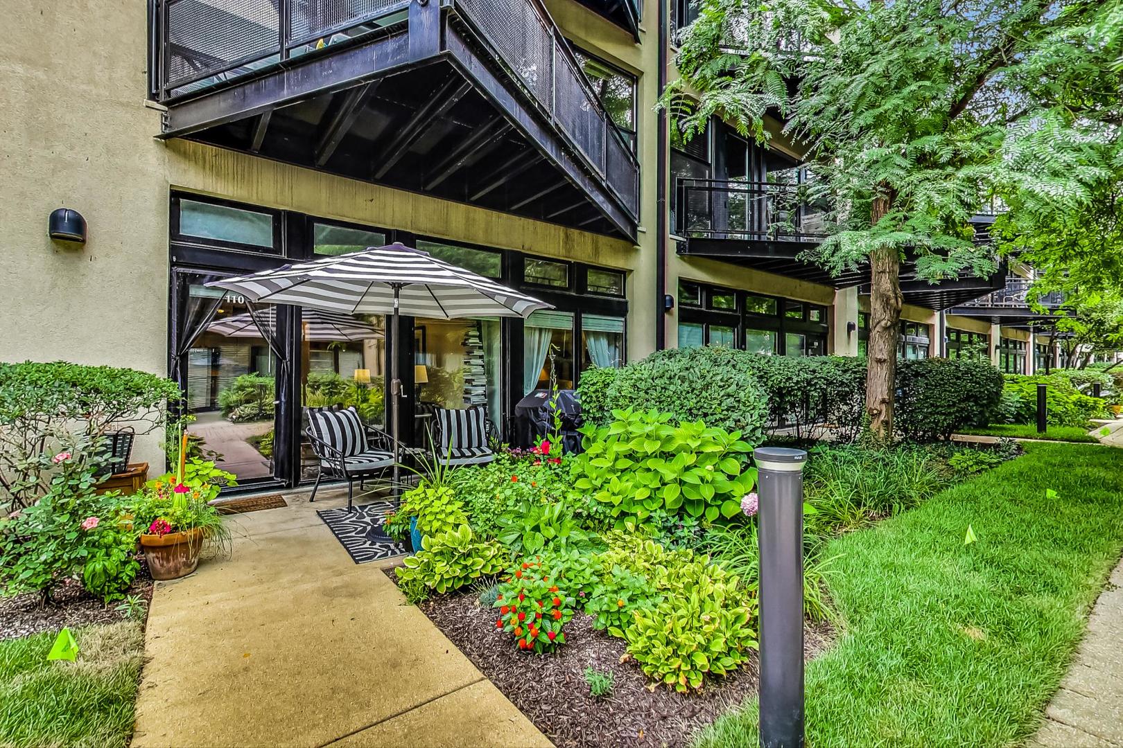 1111 West 14th Place, Unit 110 Chicago, IL 60608 - Photo 18 of 24 a view of a patio with table and chairs under an umbrella