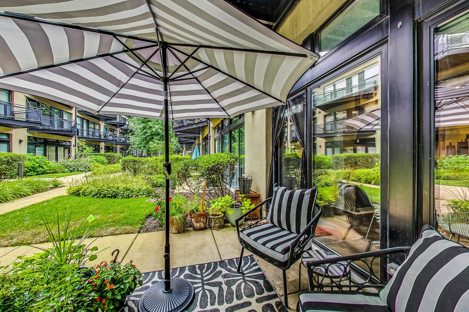 1111 West 14th Place, Unit 110 Chicago, IL 60608 - Photo 19 of 24 a patio with a patio table and chairs and potted plants