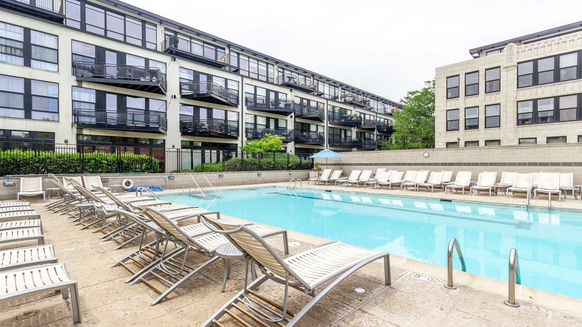 1111 West 14th Place, Unit 110 Chicago, IL 60608 - Photo 22 of 24 a view of a swimming pool with a lounge chairs