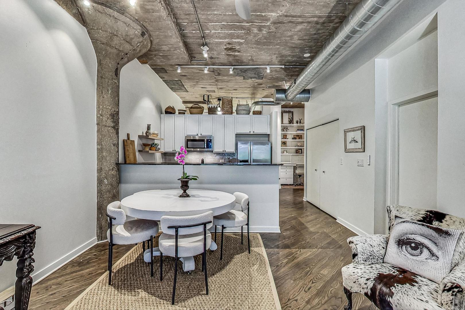 1111 West 14th Place, Unit 110 Chicago, IL 60608 - Photo 5 of 24 a dining room with furniture and a chandelier
