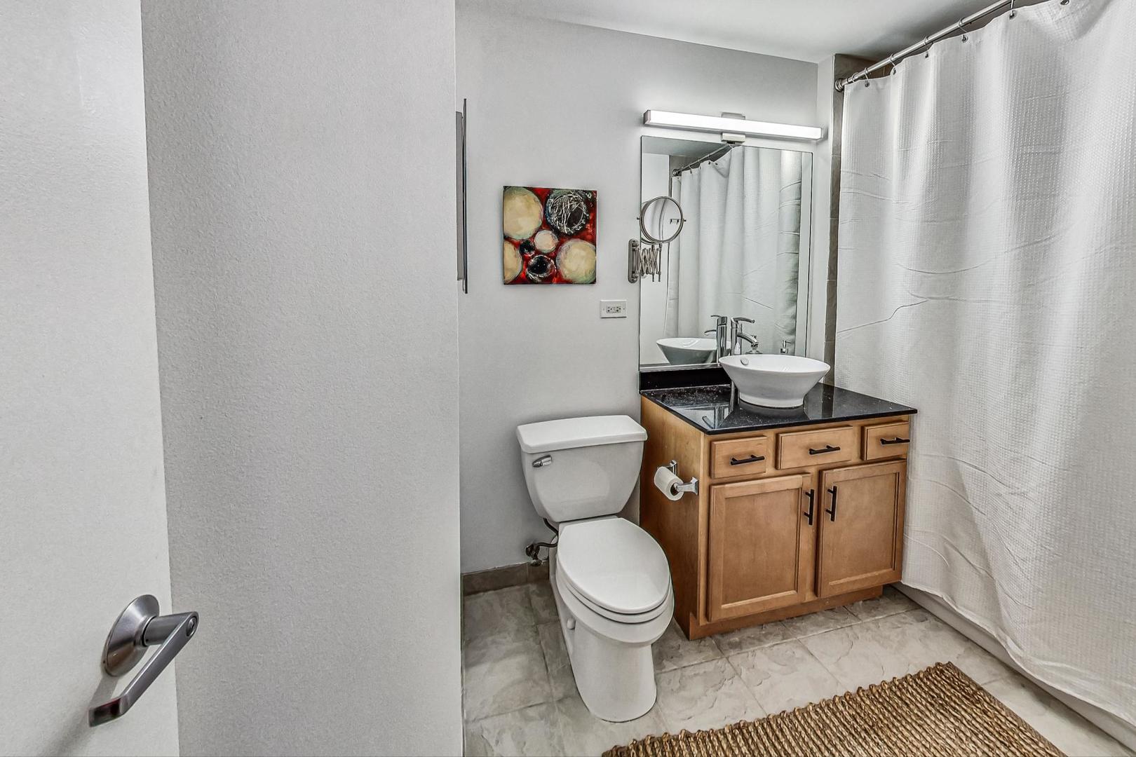 1111 West 14th Place, Unit 110 Chicago, IL 60608 - Photo 10 of 24 a bathroom with a toilet a sink and a shower