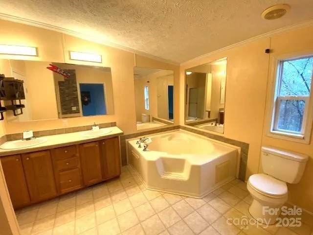 a spacious bathroom with a tub sink and mirror