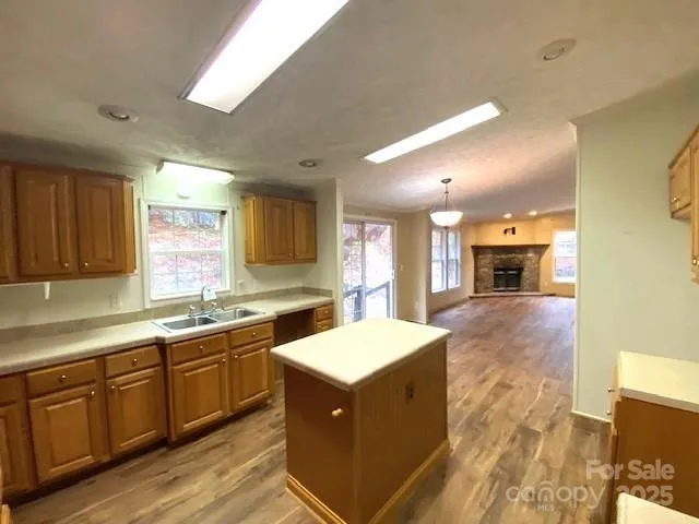 a large kitchen with a large counter top a sink stainless steel appliances and cabinets