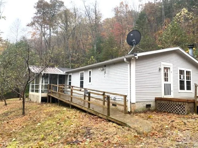 a backyard of a house with wooden fence and large trees