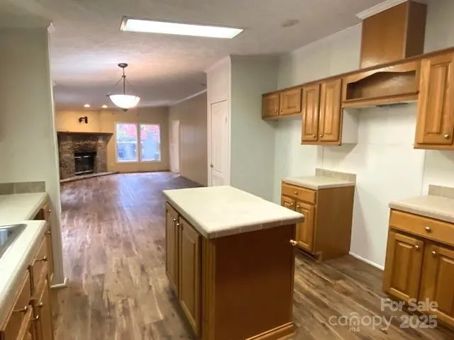 a kitchen with kitchen island a counter top space a sink stainless steel appliances and cabinets