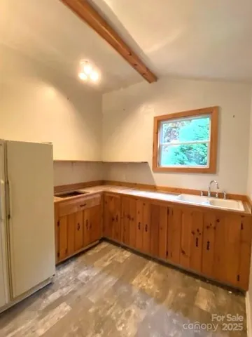 a view of a kitchen with wooden floor and electronic appliances