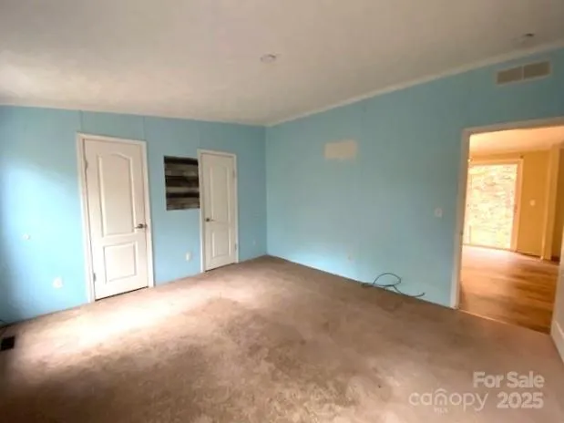 an empty room with windows and closet