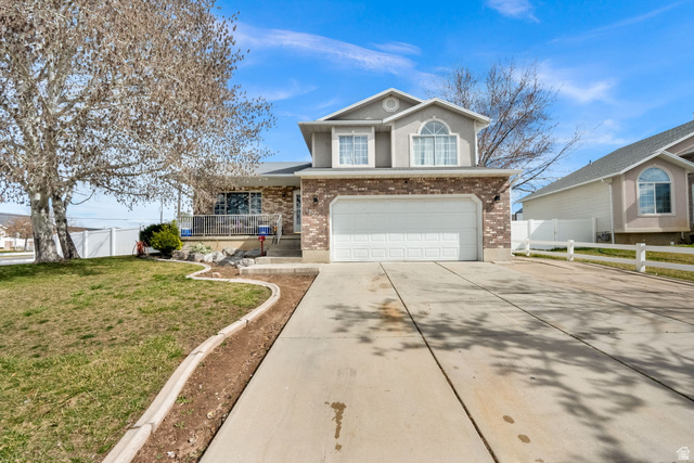 1284 North 900 West Clinton, UT 84015 - Photo 1 of 22 Traditional-style house featuring brick siding, concrete driveway, a garage, and covered porch