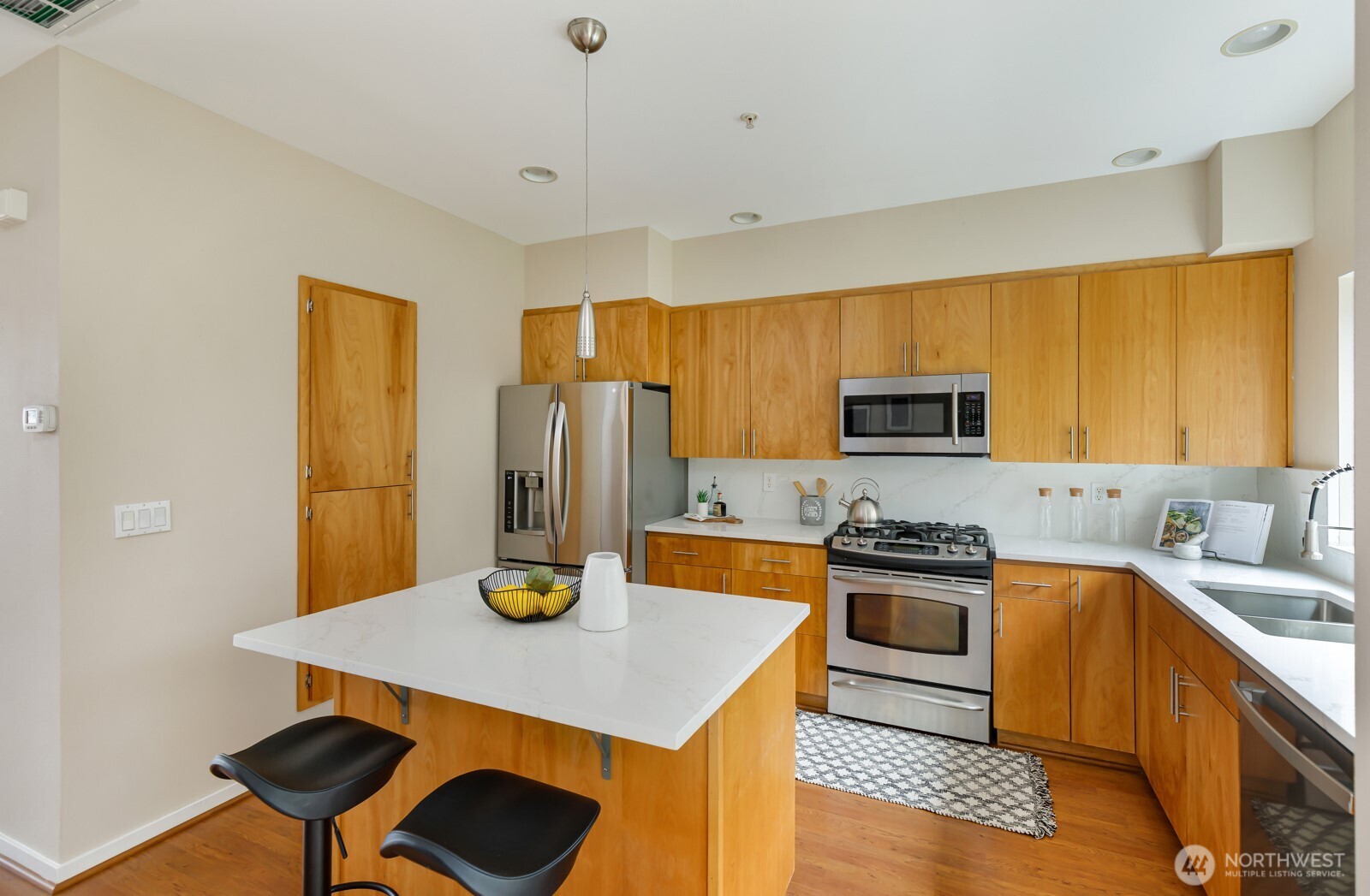 133 Cougar Ridge Road Northwest, Unit 1405 Issaquah, WA 98027 - Photo 8 of 30 a kitchen with stainless steel appliances a stove a sink cabinets and a dining table