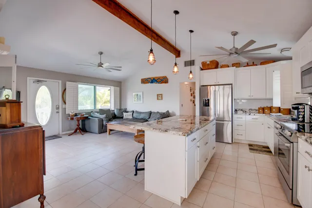 a very nice looking open kitchen with stainless steel appliances granite countertop a stove and a refrigerator