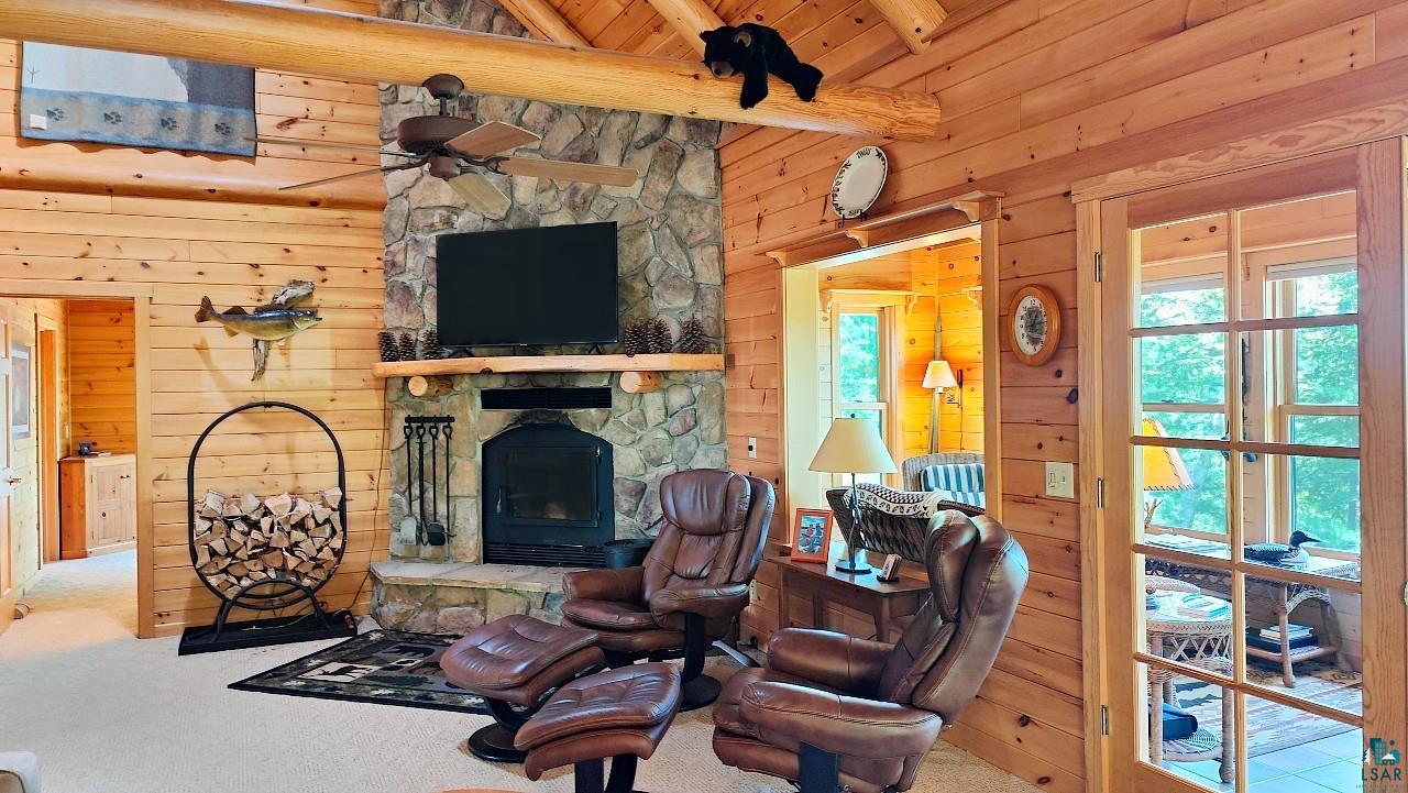 2357 Retreat Lodge Road Cook, MN 55723 - Photo 19 of 45 Carpeted living area featuring wooden walls, a ceiling fan, a fireplace, and wood ceiling