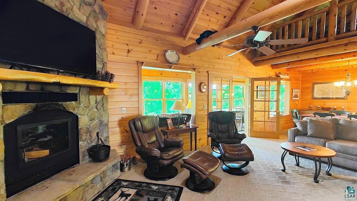 2357 Retreat Lodge Road Cook, MN 55723 - Photo 2 of 45 Living area with wooden walls, wood ceiling, ceiling fan, and a stone fireplace