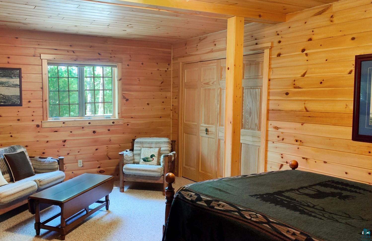 2357 Retreat Lodge Road Cook, MN 55723 - Photo 23 of 45 Bedroom featuring wooden ceiling, wood walls, and light colored carpet