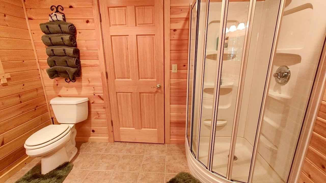 2357 Retreat Lodge Road Cook, MN 55723 - Photo 28 of 45 Bathroom with a shower stall, wooden walls, and tile patterned flooring