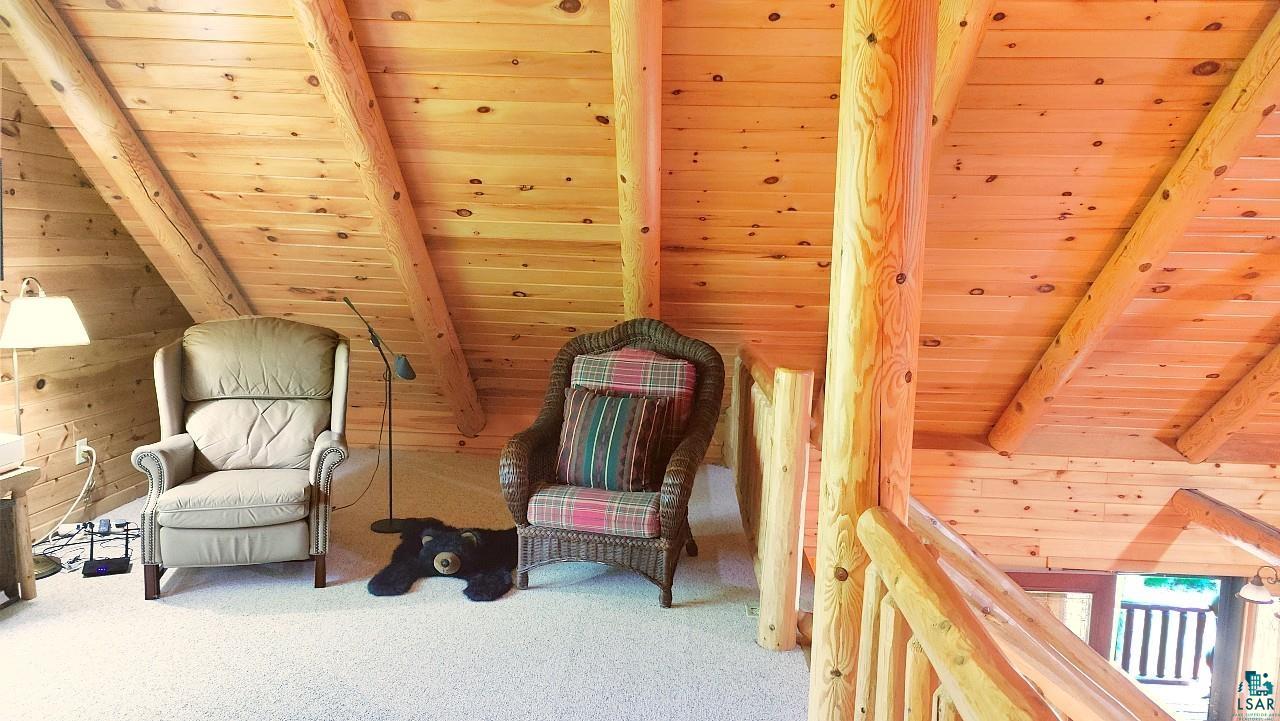 2357 Retreat Lodge Road Cook, MN 55723 - Photo 36 of 45 Living area featuring a wooden ceiling with exposed beams, wooden walls, and carpet flooring