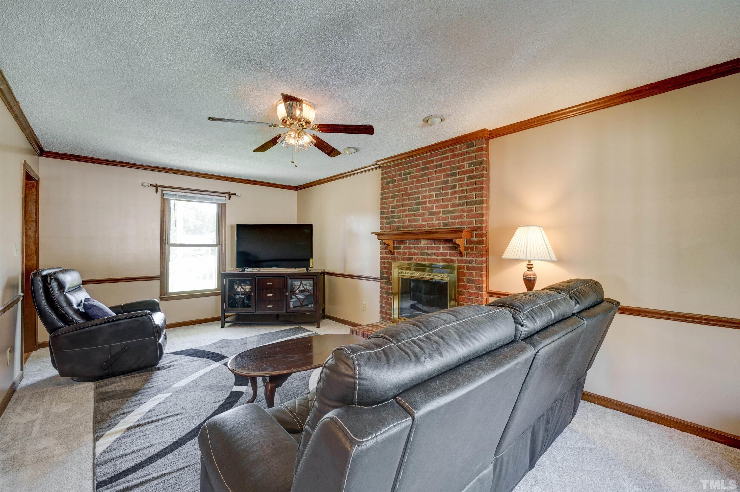 429 South Meadow Road Raleigh, NC 27603 - Photo 15 of 44 a living room with furniture and a flat screen tv