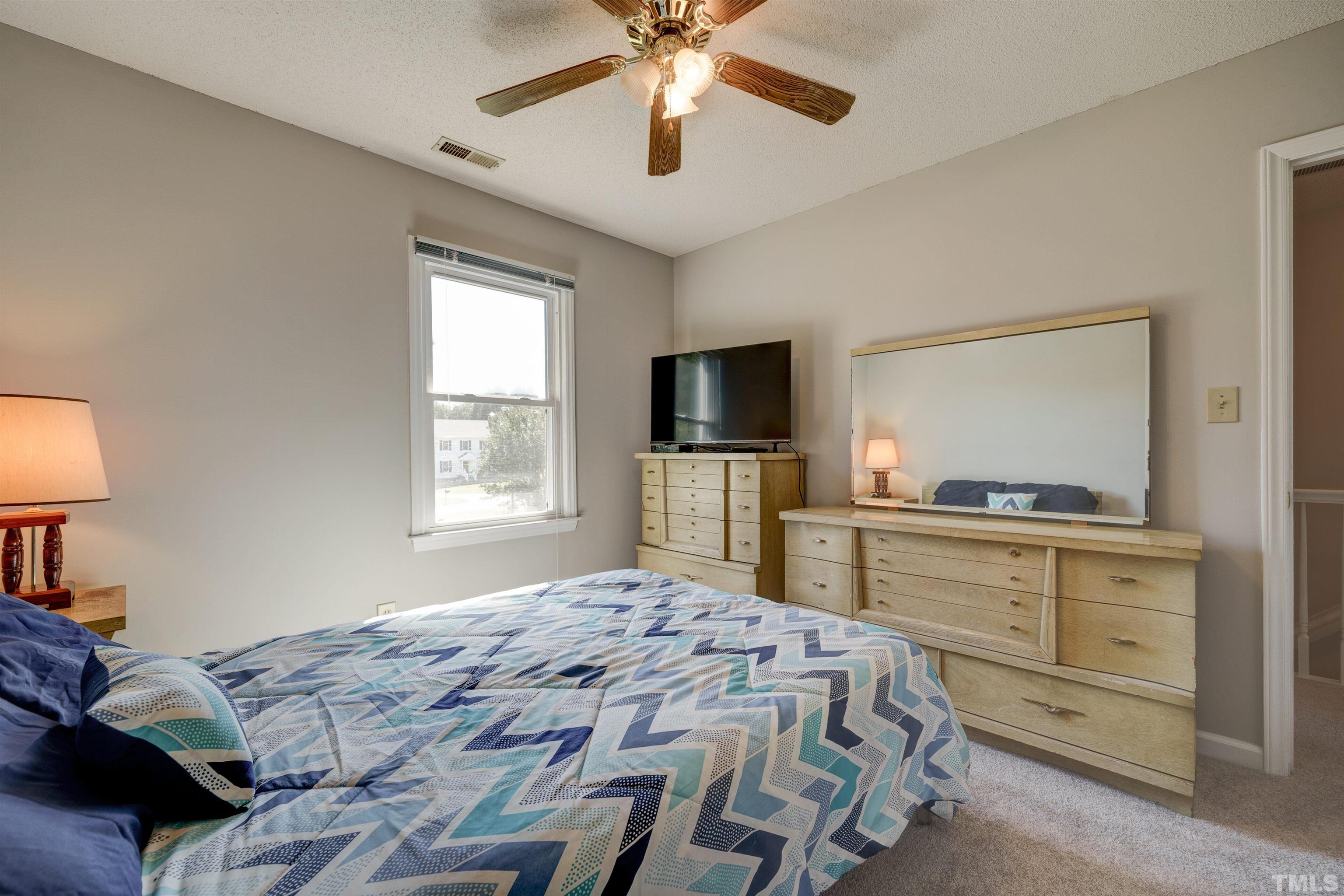 429 South Meadow Road Raleigh, NC 27603 - Photo 25 of 44 a bedroom with a bed and a flat screen tv