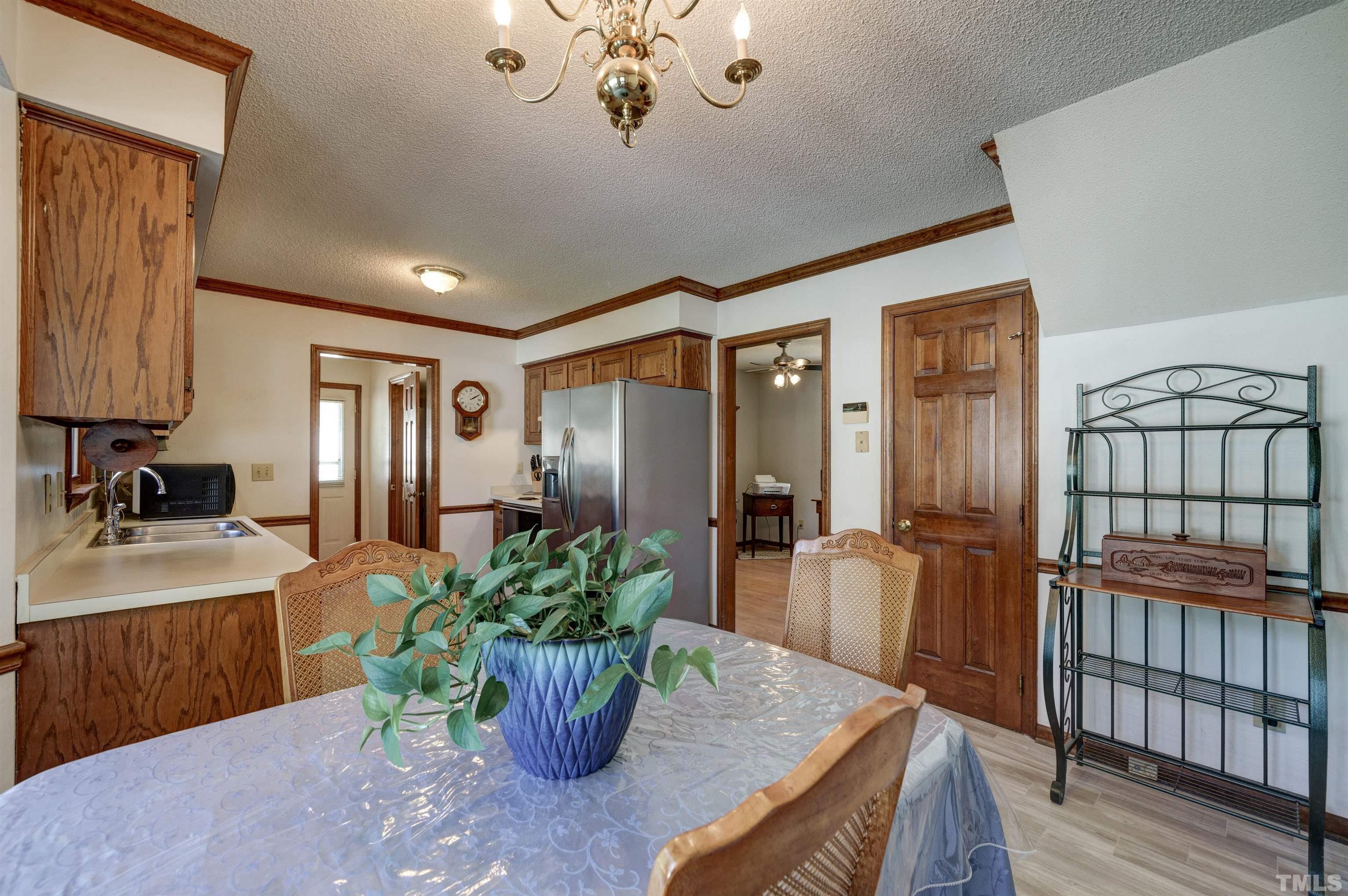 429 South Meadow Road Raleigh, NC 27603 - Photo 8 of 44 a dining room with furniture and a potted plant