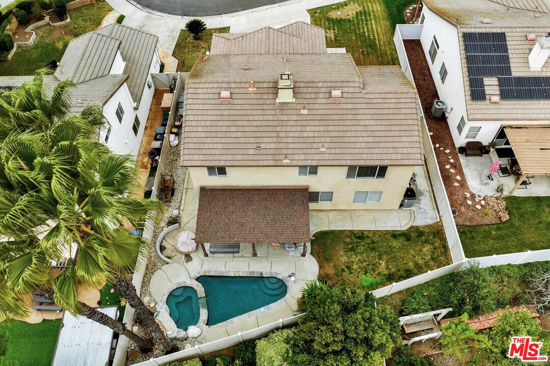 an aerial view of a house with swimming pool and porch