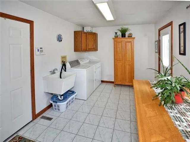 a living room with a couch and a potted plant on the wall
