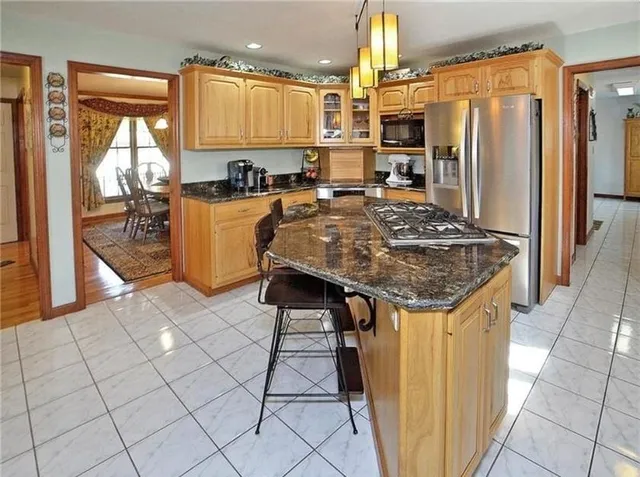 a kitchen with stainless steel appliances granite countertop a sink and a refrigerator