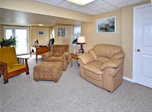 a living room with furniture and a painting on the wall