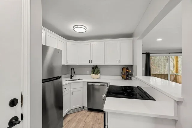 a kitchen with a sink a refrigerator and cabinets