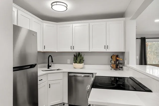a kitchen with a refrigerator and white cabinets