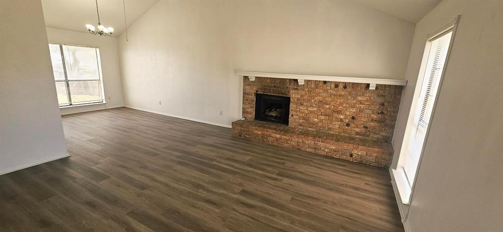 5224 Timber Creek Road Flower Mound, TX 75028 - Photo 2 of 10 an empty room with wooden floor fireplace and windows