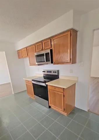 a kitchen with stainless steel appliances a stove a sink and a microwave
