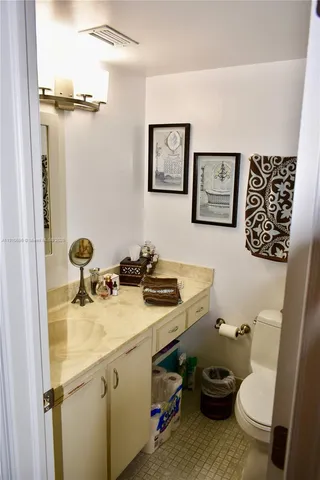 a bathroom with a sink mirror vanity and toilet