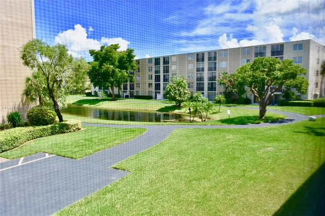 a view of a swimming pool with a bench and trees around