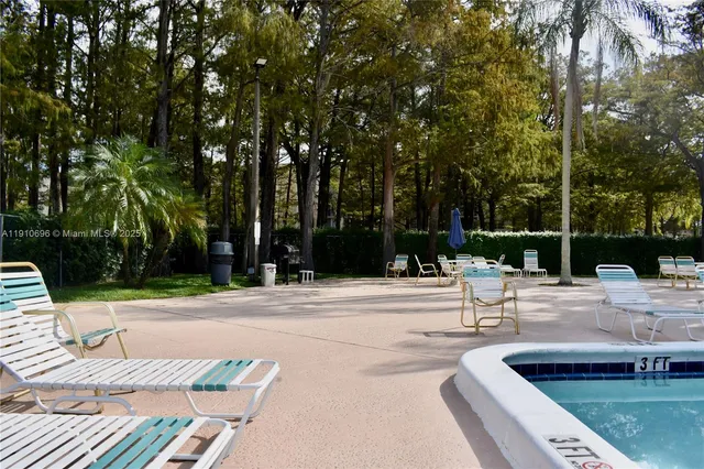 a view of swimming pool with a bench and trees