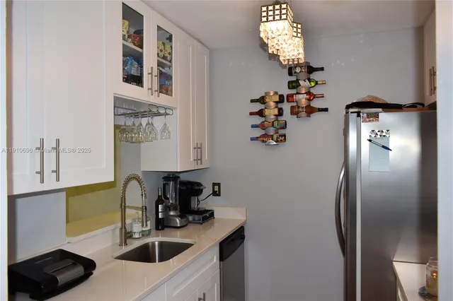 a kitchen with stainless steel appliances granite countertop a sink a refrigerator and a stove with wooden floor