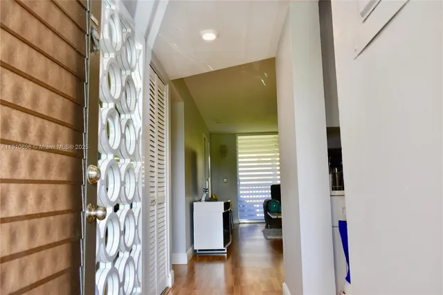 a view of a hallway with wooden floor and windows