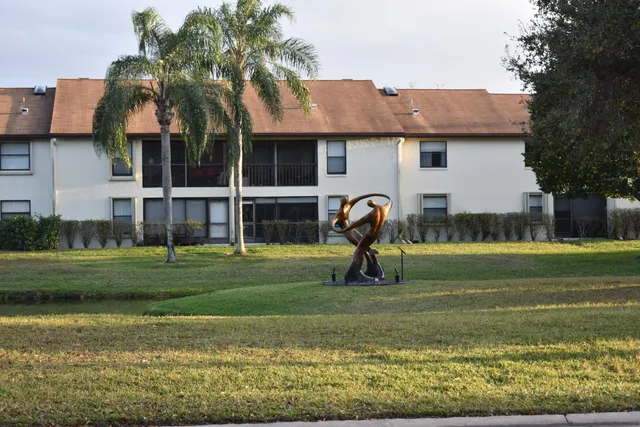 a view of a house with a backyard and a tree