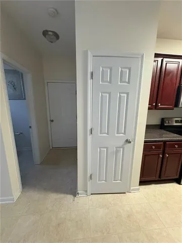 a view of an empty room with wooden floor and cabinet