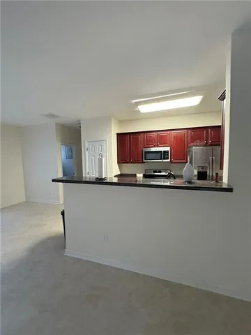 a kitchen with stainless steel appliances granite countertop a refrigerator and a stove top oven
