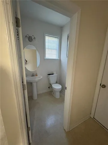 a bathroom with a toilet sink and a mirror