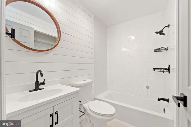 a bathroom with a sink a mirror a toilet and a bathtub