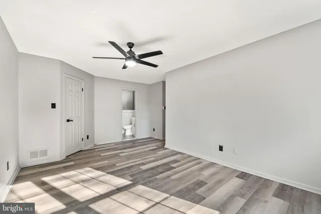 a view of a room with a chandelier fan and windows