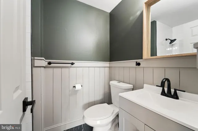 a bathroom with a sink a toilet and a mirror