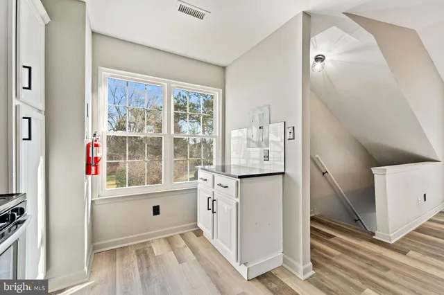 a kitchen with a stove and white cabinets