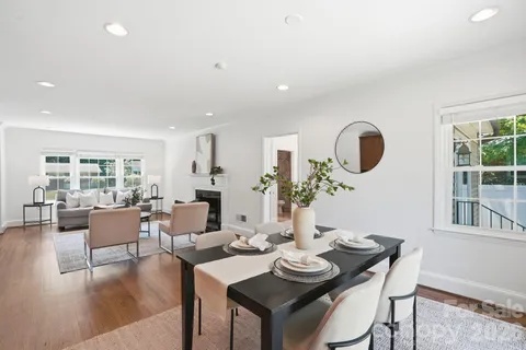a living room with furniture kitchen view and a large window