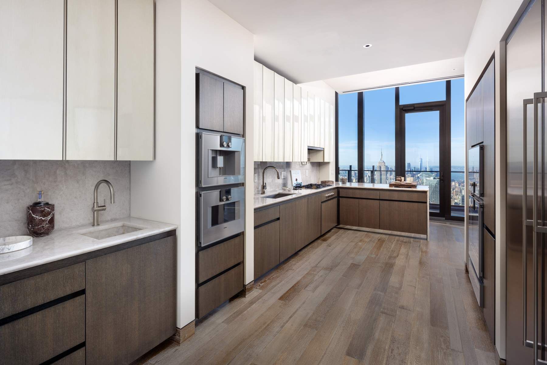 111 West 57th Street, Unit PH76 Manhattan, NY 10019 - Photo 6 of 40 a kitchen with stainless steel appliances granite countertop a sink counter space cabinets and appliances